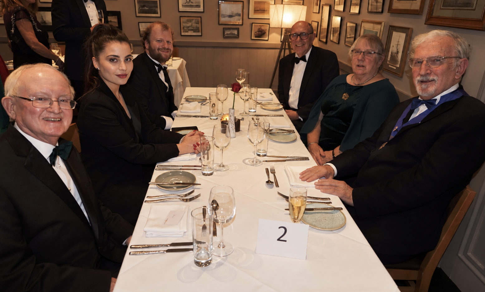 Stasia seated with a group at a formal dinner